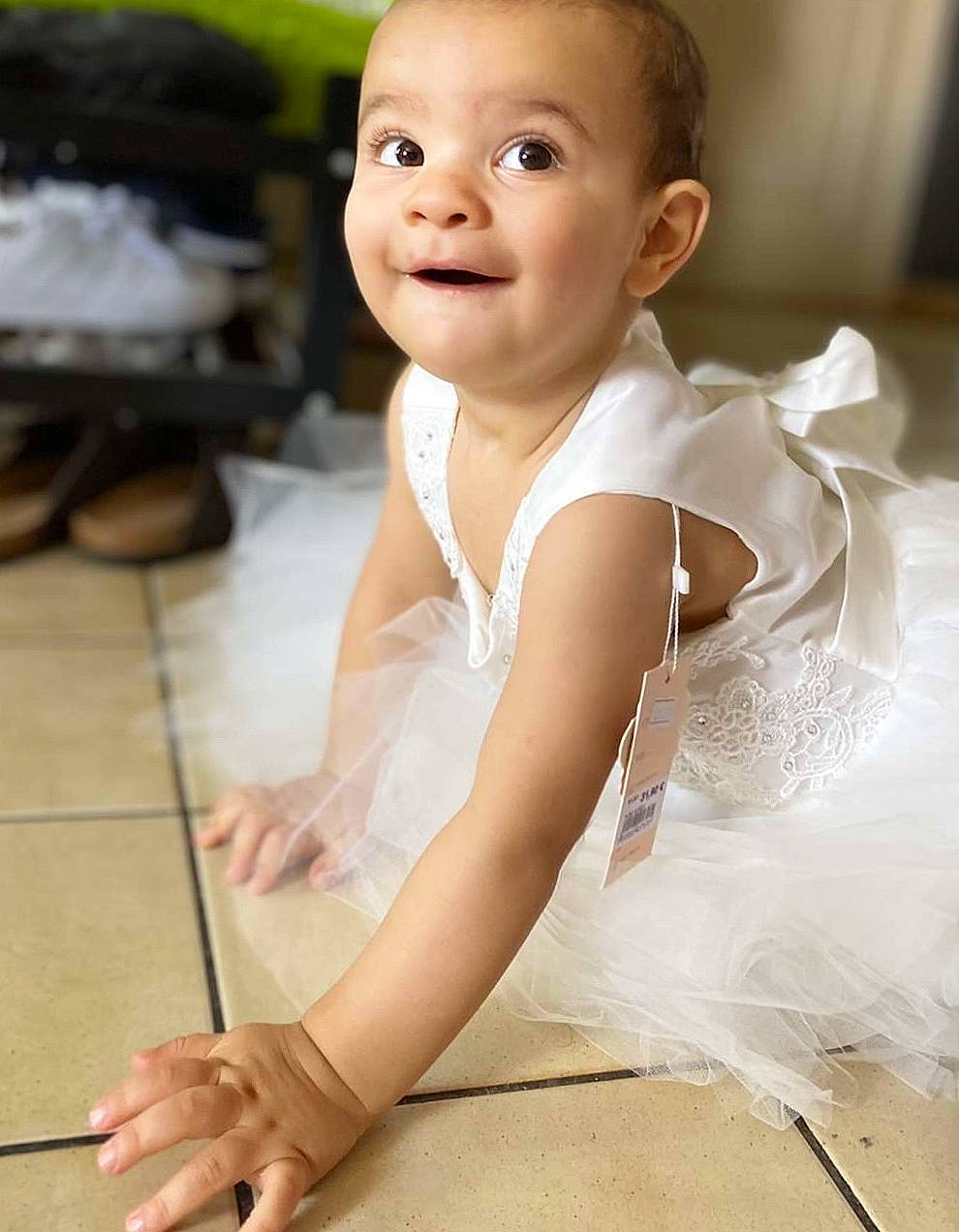 Leyna a rejoint le concours — aidez-le/la à gagner de superbes lots ! baby_toddler_clothing, dress, eyebrow, face, finger, flash_photography, floor, flooring, gesture, hand, happy, head, leg, neck, person, skin, sleeve, smile, textile, toddler
