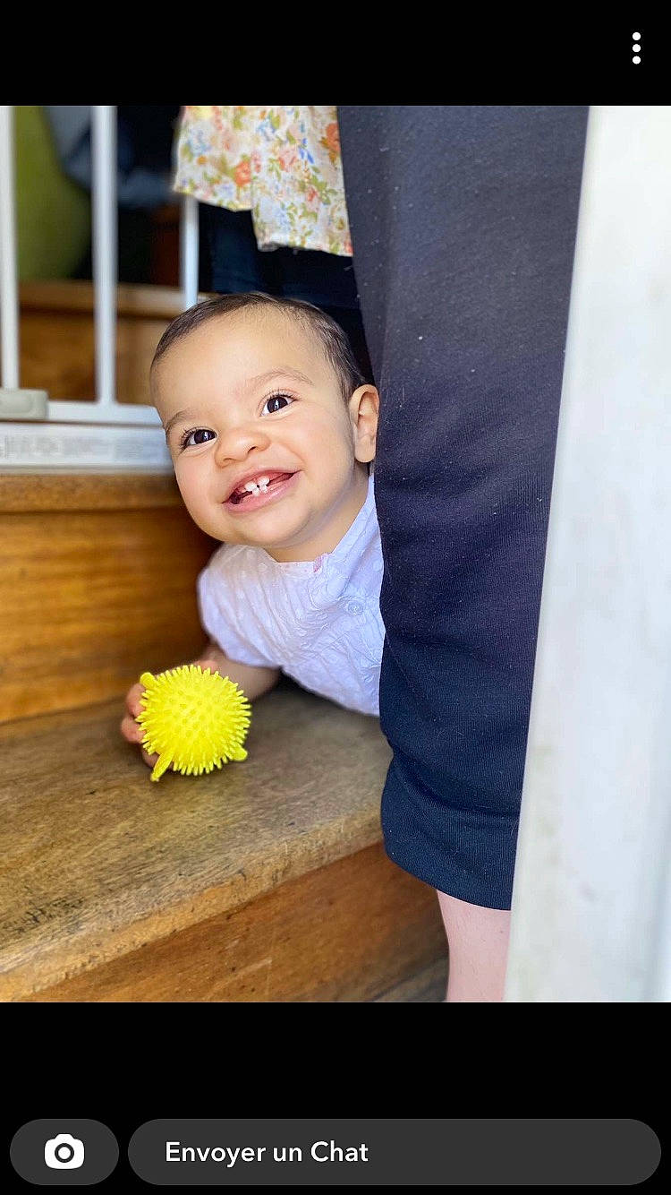 Leyna participe au concours pour gagner de l'argent avec cette photo : baby, baby_toddler_clothing, child, eye, facial_expression, finger, flooring, formal_wear, fun, hairstyle, happy, hardwood, joy, person, room, sitting, skin, smile, t_shirt, thumb
