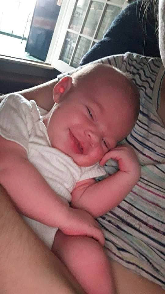 Brady is registered to the contest to win money with this photo: baby, baby_toddler_clothing, cheek, chest, comfort, eye, eyebrow, eyelash, finger, human_body, iris, linens, lip, mouth, neck, nose, person, skin, smile, thumb
