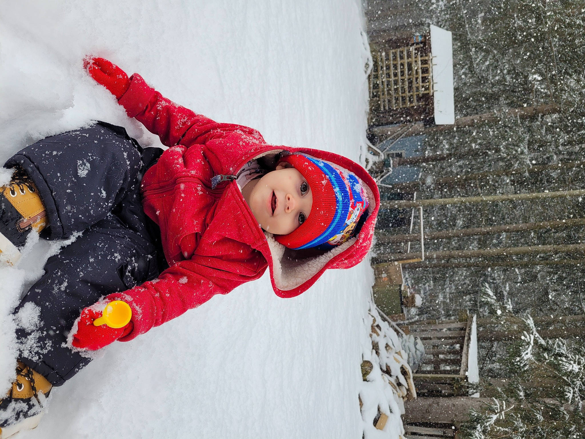 Brady joined the competition — help win amazing prizes! building, carmine, event, freezing, fun, glove, hat, headgear, headwear, jacket, leisure, person, personal_protective_equipment, plant, playing_in_the_snow, recreation, smile, snow, toddler, tree