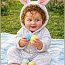 baby, child, bunny_costume, curly_hair, easter_eggs, grass, outdoor, blanket, smile, blue_eyes, cute, spring, greenery, pink_ears, playful, nature, soft_texture, holiday, happy, portrait