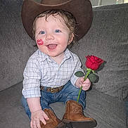 Skyler joined the competition — help win amazing prizes! blue_eyes, boots, child, couch, cowboy_hat, cute, face, happy, indoor, jeans, lipstick_mark, person, plaid_shirt, playful, portrait, rose, sitting, smiling, toddler, young_child