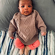 Nina joined the competition — help win amazing prizes! baby, bed, child, cozy, cute, face, feet, hands, indoors, infant, knitwear, leggings, looking, person, pillow, portrait, sitting, soft_lighting, striped_bedspread, sweater