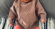 Nina joined the competition — help win amazing prizes! baby, bed, child, cozy, cute, face, feet, hands, indoors, infant, knitwear, leggings, looking, person, pillow, portrait, sitting, soft_lighting, striped_bedspread, sweater