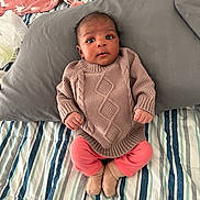 Nina joined the competition — help win amazing prizes! baby, infant, knitted_sweater, pink_pants, socks, bed, pillow, striped_bedspread, curious, alert, indoors, child, person, clothing, furniture, soft_toys, casual, portrait, cute, newborn