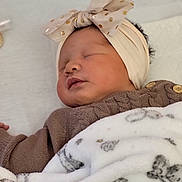 Kessy participe au concours pour gagner de l'argent avec cette photo : baby, sleeping, blanket, headband, bow, polka_dots, knitted_sweater, face, infant, close_up, cozy, soft_texture, cute, peaceful, newborn, child, indoors, portrait, resting, warm
