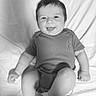 Elijah is registered to the contest to win money with this photo: baby, infant, smiling, tongue_out, black_and_white, portrait, cute, child, happy, one_person, sitting, short_sleeve, clothing, fabric, background, indoor, skin, head, face, young