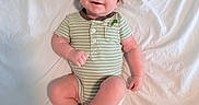 Elijah joined the competition — help win amazing prizes! baby, infant, child, smiling, green_onesie, striped_clothing, dinosaur_print, lying_down, white_sheet, happy, cute, portrait, skin, face, head, hands, legs, feet, indoors, soft_lighting