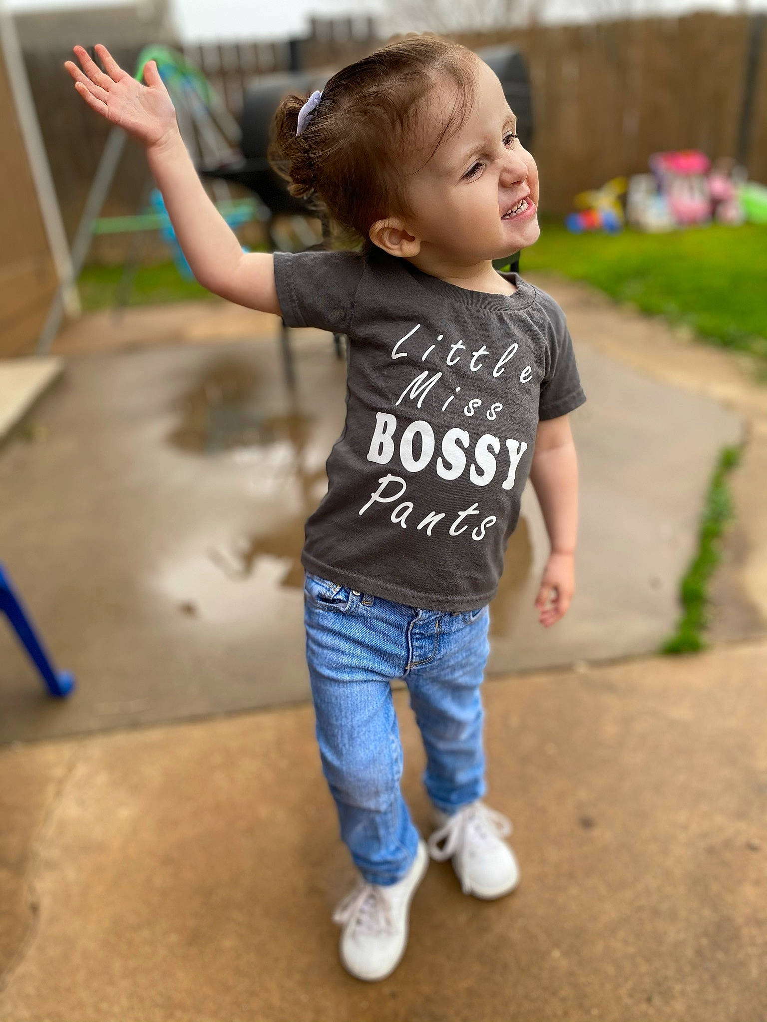 Maisie is registered to the contest to win money with this photo: child, clothing, eye, gesture, grass, hair, hand, happy, head, jeans, leg, leisure, person, shoulder, skin, sleeve, smile, standing, t_shirt, toddler