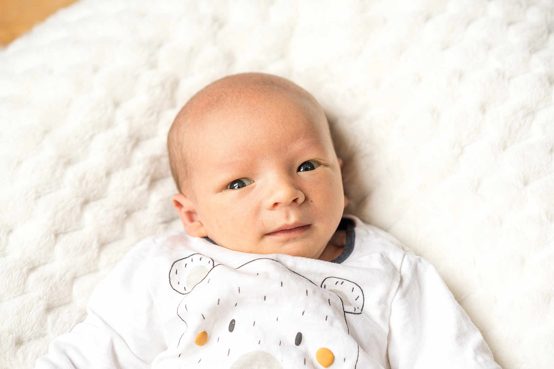 Nathan participe au concours pour gagner de l'argent avec cette photo : baby, newborn, infant, face, eyes, blanket, white, soft, texture, clothing, onesie, bear, cute, portrait, lying_down, skin, head, small, child, indoors