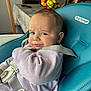 baby, child, high_chair, purple_clothing, teal_chair, face, expression, indoor, dining_room, fruit_basket, wooden_chairs, table, straps, onesie, person, infant, seat, curious, candid, home