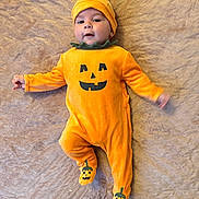 Ionuț Elisei participe au concours pour gagner de l'argent avec cette photo : baby, pumpkin_costume, orange, cute, child, infant, blanket, costume, halloween, smiling, lying_down, face, headwear, footwear, green, one_person, indoors, soft_texture, happy, playful