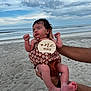 Aurora joined the competition — help win amazing prizes! baby, beach, clothing, clouds, cute, floral_pattern, hands, holding, infant, newborn, ocean, outdoor, peaceful, person, portrait, sand, skin, sky, sleeping, summer