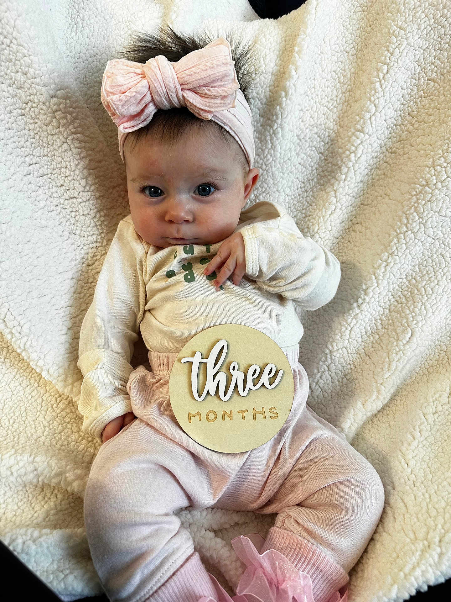 Madilyn is registered to the contest to win money with this photo: baby, infant, child, headband, bow, clothing, pink, blanket, soft_texture, milestone, sign, wooden_sign, cute, portrait, sitting, indoors, person, face, expression, cozy