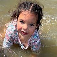 Mia joined the competition — help win amazing prizes! child, water, smiling, playing, outdoor, curly_hair, floral_shirt, face, happy, sunlight, nature, young_child, portrait, joy, summer, water_splash, casual_clothing, necklace, daylight, fun