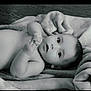 baby, infant, blanket, soft_texture, lying_down, curious, wide_eyes, hands, skin, face, portrait, monochrome, black_and_white, young_child, cute, peaceful, indoors, newborn, child, resting
