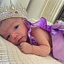 Samadhi is registered to the contest to win money with this photo: baby, crown, purple_dress, blanket, face, infant, closeup, portrait, lying_down, soft_texture, bedroom, cute, newborn, sleeping_area, skin, hand, decor, resting, young_child, indoor
