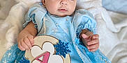 Samadhi is registered to the contest to win money with this photo: baby, infant, blue_dress, snowflake, sign, 4_months, blanket, cute, portrait, child, smiling, soft_texture, lying_down, earrings, chubby, celebration, indoor, head, hand, foot