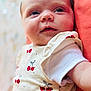 Maddy participe au concours pour gagner de l'argent avec cette photo : apparel, baby, cherry, child, closeup, clothing, cute, expression, eyes, fabric, face, infant, lying_down, newborn, pattern, portrait, red, skin, soft, white