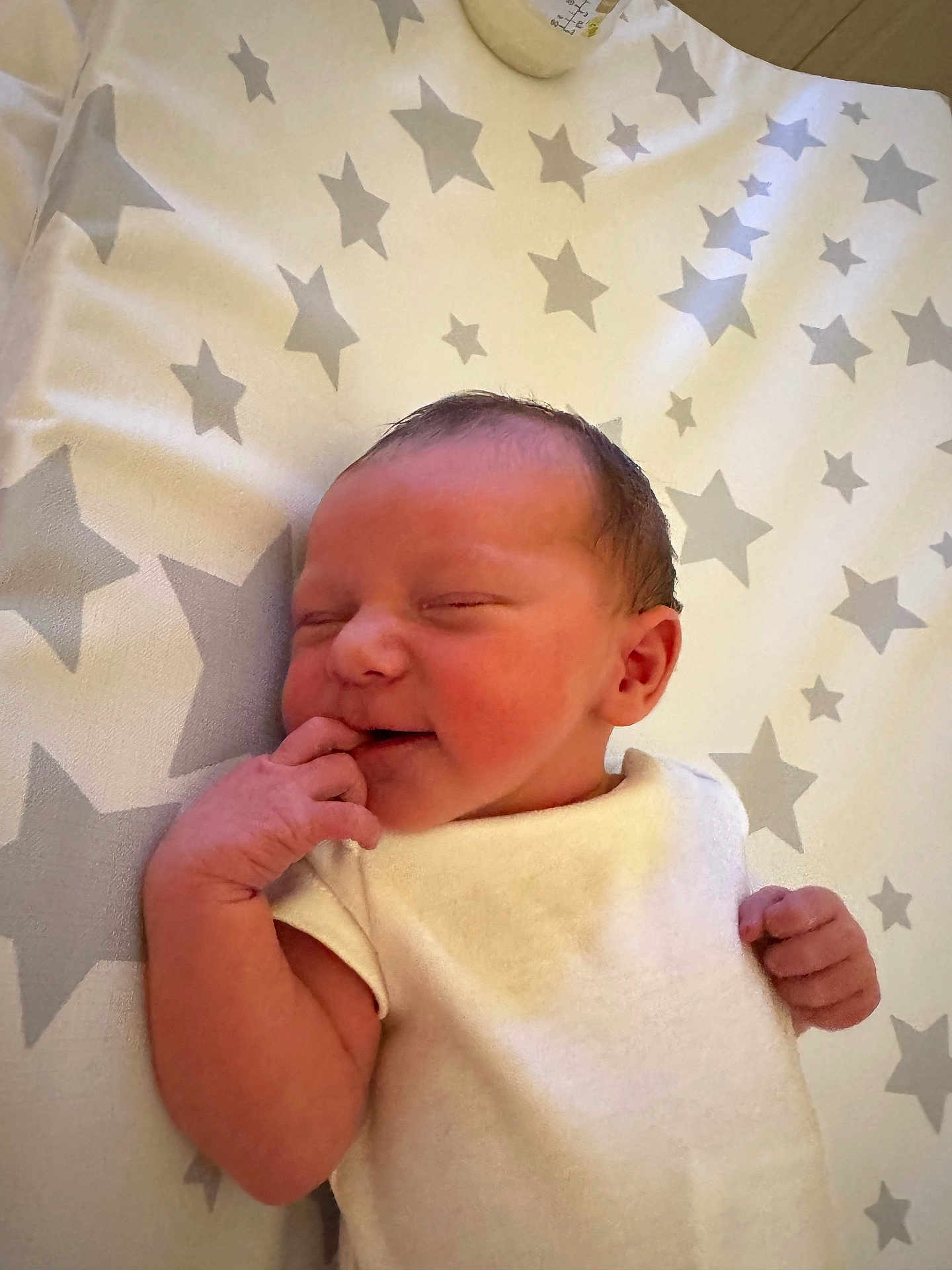 Sandy-Ann is registered to the contest to win money with this photo: newborn, baby, infant, sleeping, blanket, stars, pattern, hand, face, skin, cute, peaceful, white_clothing, lying_down, small, adorable, indoors, soft, portrait, child