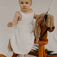Gabriella is registered to the contest to win money with this photo: baby, bed, chair, clothing, cradle, crib, dress, face, furniture, hardwood, head, homedecor, infantbed, person, photography, portrait, rockingchair, sitting, toy, wood
