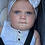 baby, child, blue_eyes, headband, bow, white_clothing, car_seat, straps, serious_expression, close_up, infant, face, portrait, sitting, cute, skin, hair, indoors, seatbelt, young_child