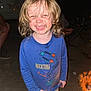 child, smiling, blonde_hair, dirt, blue_shirt, rocket_design, night, campfire, outdoor, happy, toddler, portrait, face, clothing, person, sand, fire, casual, cute, joyful