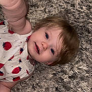 Violet joined the competition — help win amazing prizes! toddler, child, baby, carpet, fluffy, reaching_hand, strawberry_print, dress, curious, joyful, blue_eyes, blond_hair, indoor, closeup, skin, person, smiling, portrait, lying_down, cute