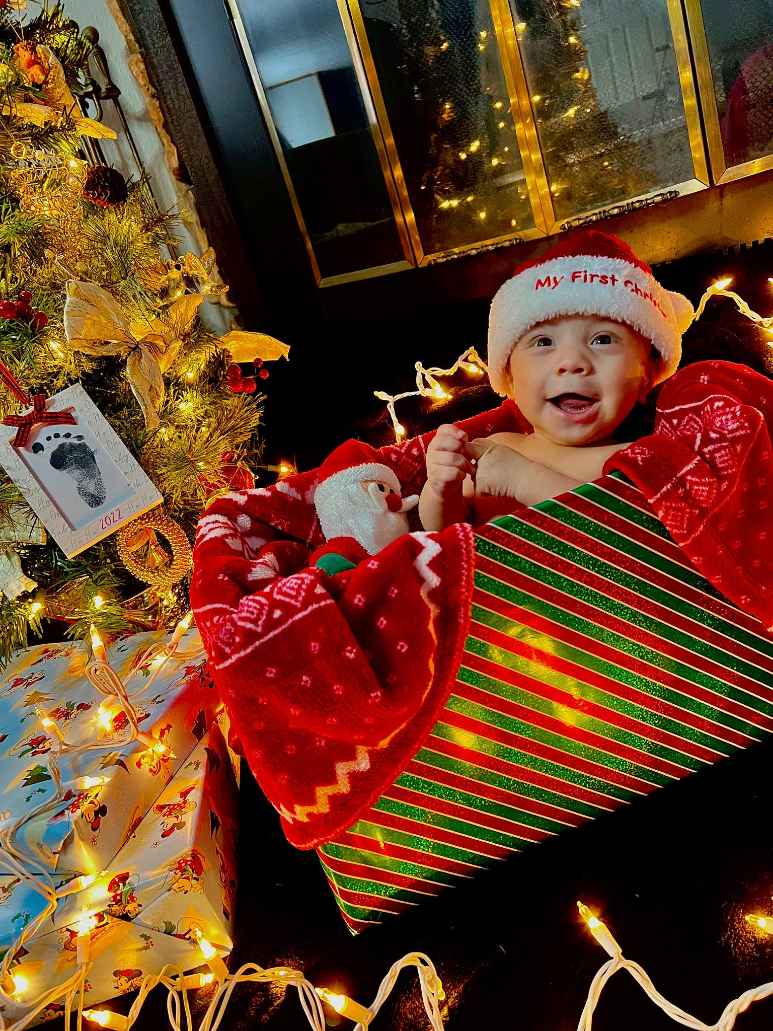 Armani is registered to the contest to win money with this photo: baby_toddler_clothing, carmine, christmas, christmas_decoration, christmas_eve, christmas_lights, christmas_ornament, decoration, event, fictional_character, fun, happy, headwear, holiday, interior_design, ornament, pattern, person, toddler, tradition