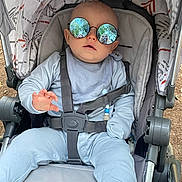 Anakin is registered to the contest to win money with this photo: baby, stroller, sunglasses, reflection, child, outdoor, person_reflection, blue_clothing, seatbelt, infant, sun_glasses, baby_boy, casual, relaxed, baby_seat, baby_accessory, daylight, fashion, cute, portrait