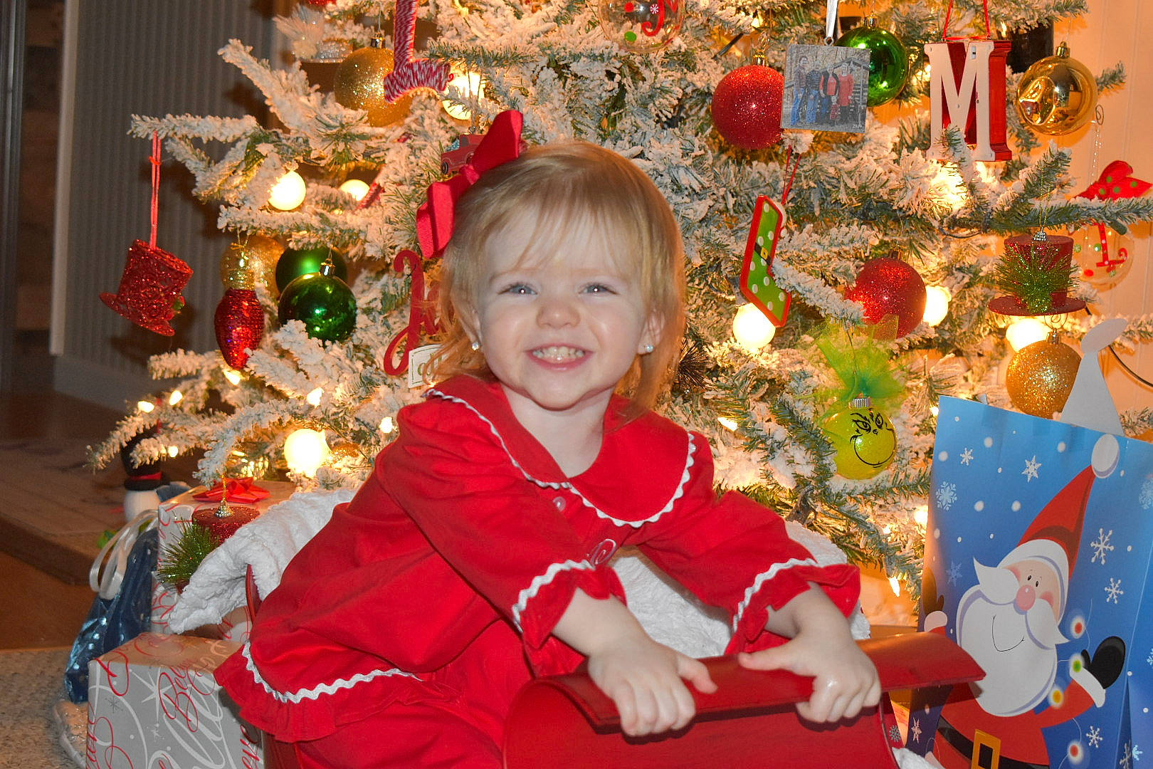 Logan is registered to the contest to win money with this photo: child, christmas, christmas_decoration, christmas_eve, christmas_lights, christmas_ornament, christmas_tree, event, fictional_character, happy, holiday, holiday_ornament, interior_design, joy, ornament, person, smile, toddler, tree
