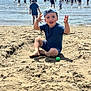 toddler, child, beach, sand, water, ocean, ball, cap, blue_clothing, summer, sunny, people, playing, outdoor, vacation, sandcastle, happy, barefoot, daytime, fun