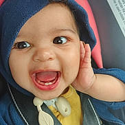 Chianne is registered to the contest to win money with this photo: baby, child, smiling, happy, hoodie, car_seat, safety_harness, teeth, hand, face, cute, infant, blue_clothing, yellow_shirt, plastic_toy, closeup, portrait, indoors, seatbelt, baby_accessory