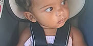Chianne is registered to the contest to win money with this photo: baby, child, car_seat, safety_harness, hair_buns, curious, looking_away, infant, seatbelt, toddler, clothing, indoor, cute, person, skin, hands, toy, colorful, seat, young
