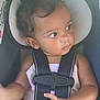 baby, child, car_seat, safety_harness, hair_buns, curious, looking_away, infant, seatbelt, toddler, clothing, indoor, cute, person, skin, hands, toy, colorful, seat, young