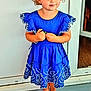 barefoot, blue_dress, casual, child, curly_hair, cute, door, fashion, feet, happy, holding_object, innocence, outdoor, person, playful, portrait, smile, standing, toddler, young_child