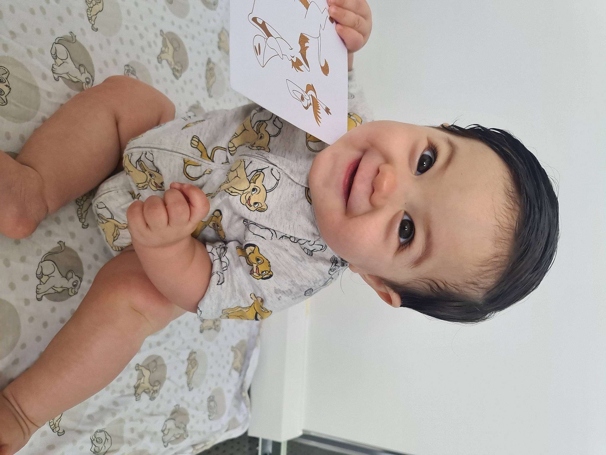 Zaire is registered to the contest to win money with this photo: baby, baby_toddler_clothing, cheek, child, dress, eyelash, facial_expression, gesture, happy, joy, linens, nail, nose, pattern, person, room, skin, sleeve, smile, toddler