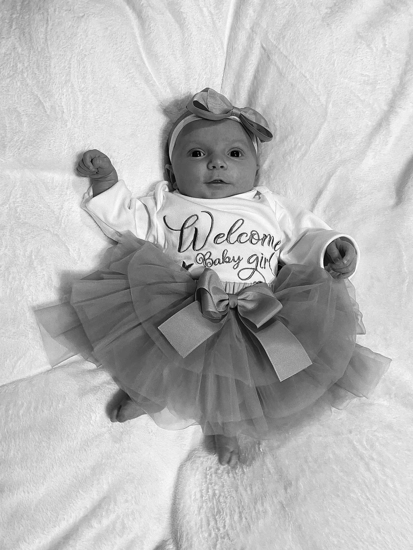 Linaya participe au concours pour gagner de l'argent avec cette photo : baby, infant, tutu, headband, bow, blanket, newborn, clothing, cute, portrait, laying_down, soft_texture, monochrome, smiling, face, hands, feet, girl, apparel, fabric