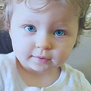 Lily Rose a rejoint le concours — aidez-le/la à gagner de superbes lots ! child, baby, toddler, face, blue_eyes, curly_hair, portrait, close_up, indoor, onesie, clothing, soft_light, cheeks, nose, mouth, eyelashes, gaze, adorable, sitting, hair