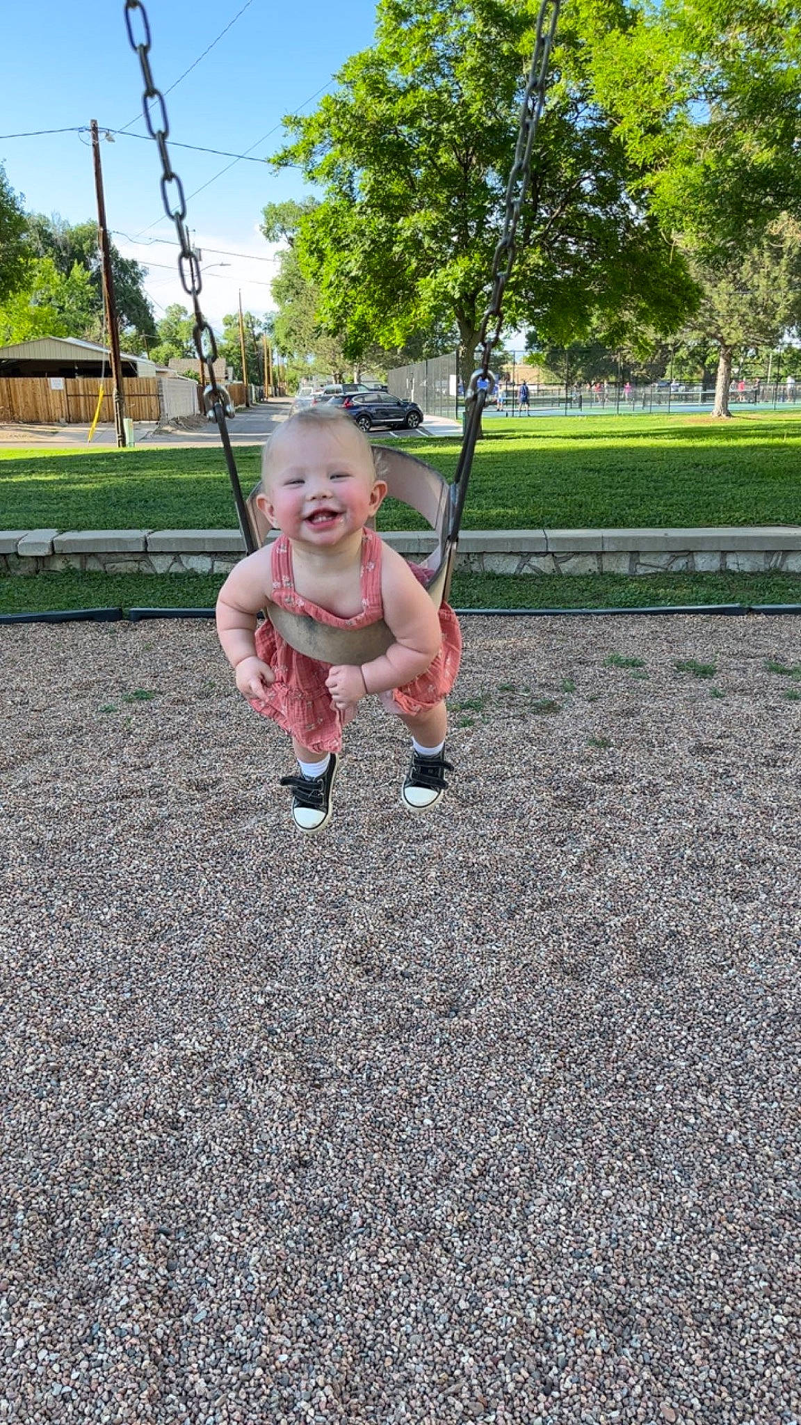 Ashtyn is registered to the contest to win money with this photo: asphalt, baby, city, fun, grass, happy, human_leg, joy, leisure, outdoor_play_equipment, person, plant, playground, recreation, shorts, sky, smile, soil, swing, thumb