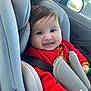 baby, baby_toddler, car_interior, car_seat, child, clothing, face, happy, head_support, indoors, knitted_clothing, portrait, red_sweater, reflection, seat, seatbelt, smile, vehicle, window, young_child