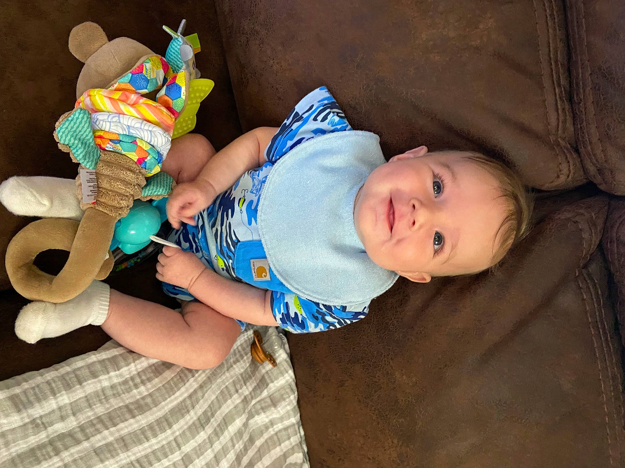 Ezrah is registered to the contest to win money with this photo: baby, baby_products, baby_safety, baby_toddler_clothing, cheek, child, comfort, fun, happy, headgear, nail, pattern, person, plush, sitting, skin, sleeve, smile, stuffed_toy, toddler