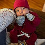 baby, child, closeup, couch, cozy, cute, hand, hat, indoor, infant, knitwear, mittens, moccasins, person, portrait, red_clothing, seated, soft_lighting, warm_colors, wood_floor