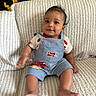 Lennox joined the competition — help win amazing prizes! baby, child, smiling, sitting, couch, overalls, clothing, hand, foot, face, indoor, textured_fabric, happy, portrait, cute, young_child, skin, person, infant, casual