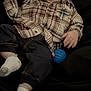 baby, blue_ball, casual_clothing, child, cozy, cute, dark_pants, face, happy, indoors, infant, joyful, lying_down, person, plaid_shirt, small_feet, small_hands, smiling, socks, young_child