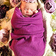 Zuri Lynn joined the competition — help win amazing prizes! newborn, baby, sleeping, purple_blanket, flower_headband, swaddled, floral_arrangement, lace_background, peaceful, infant, portrait, closeup, soft_lighting, decorative_flowers, wrapped, cute, resting, indoors, head, child
