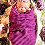 newborn, baby, sleeping, purple_blanket, flower_headband, swaddled, floral_arrangement, lace_background, peaceful, infant, portrait, closeup, soft_lighting, decorative_flowers, wrapped, cute, resting, indoors, head, child