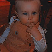Skyla is registered to the contest to win money with this photo: baby, child, infant, portrait, sitting, high_chair, wooden_chair, indoor, restaurant, dining_area, brown_clothing, overalls, long_sleeves, blue_eyes, hand, finger, curious, calm, warm_lighting, face