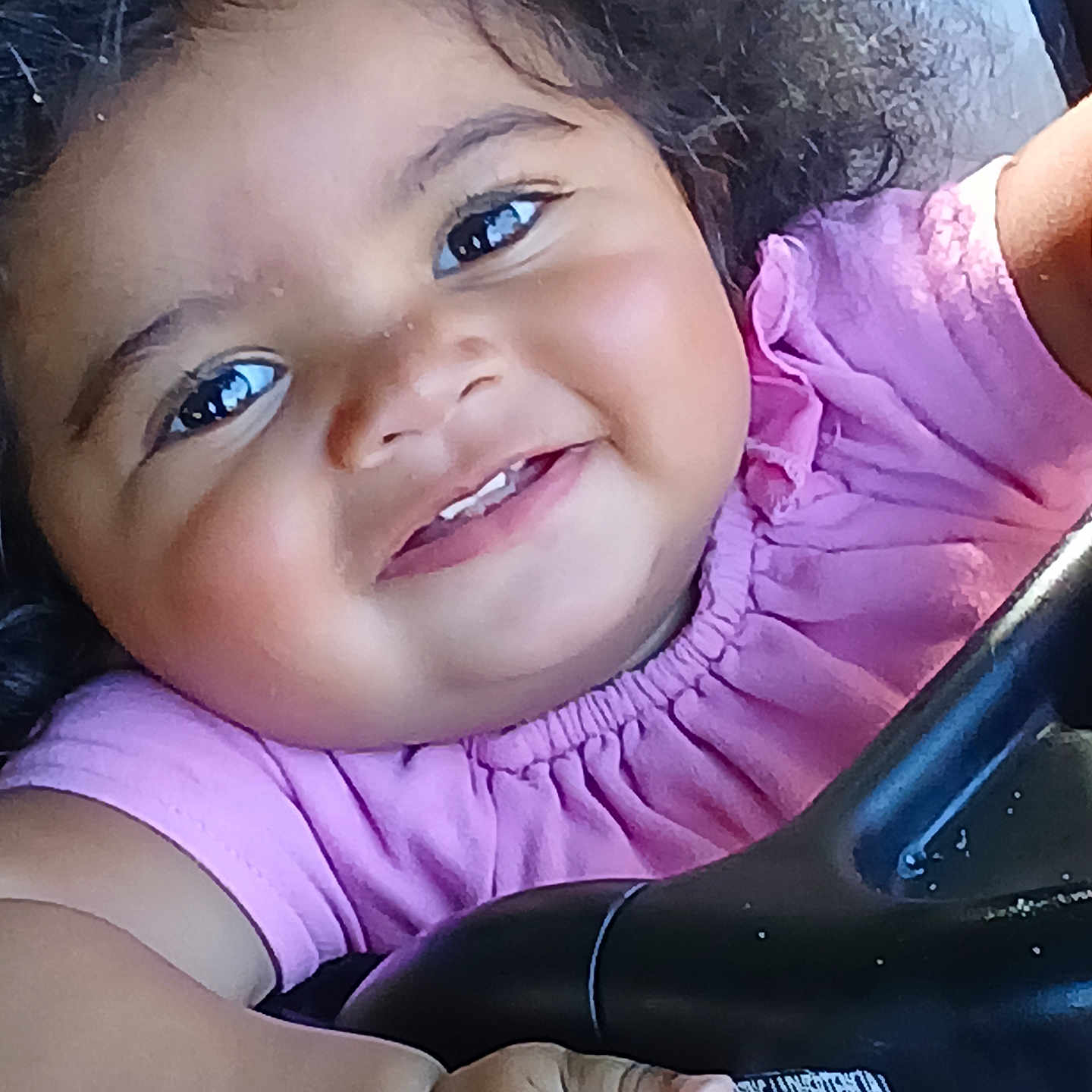 Akeilah is registered to the contest to win money with this photo: baby, cheeks, child, close_up, clothing, curly_hair, cute, expression, eyes, face, hand, happy, holding, infant, person, pink_shirt, portrait, skin, smiling, toddler