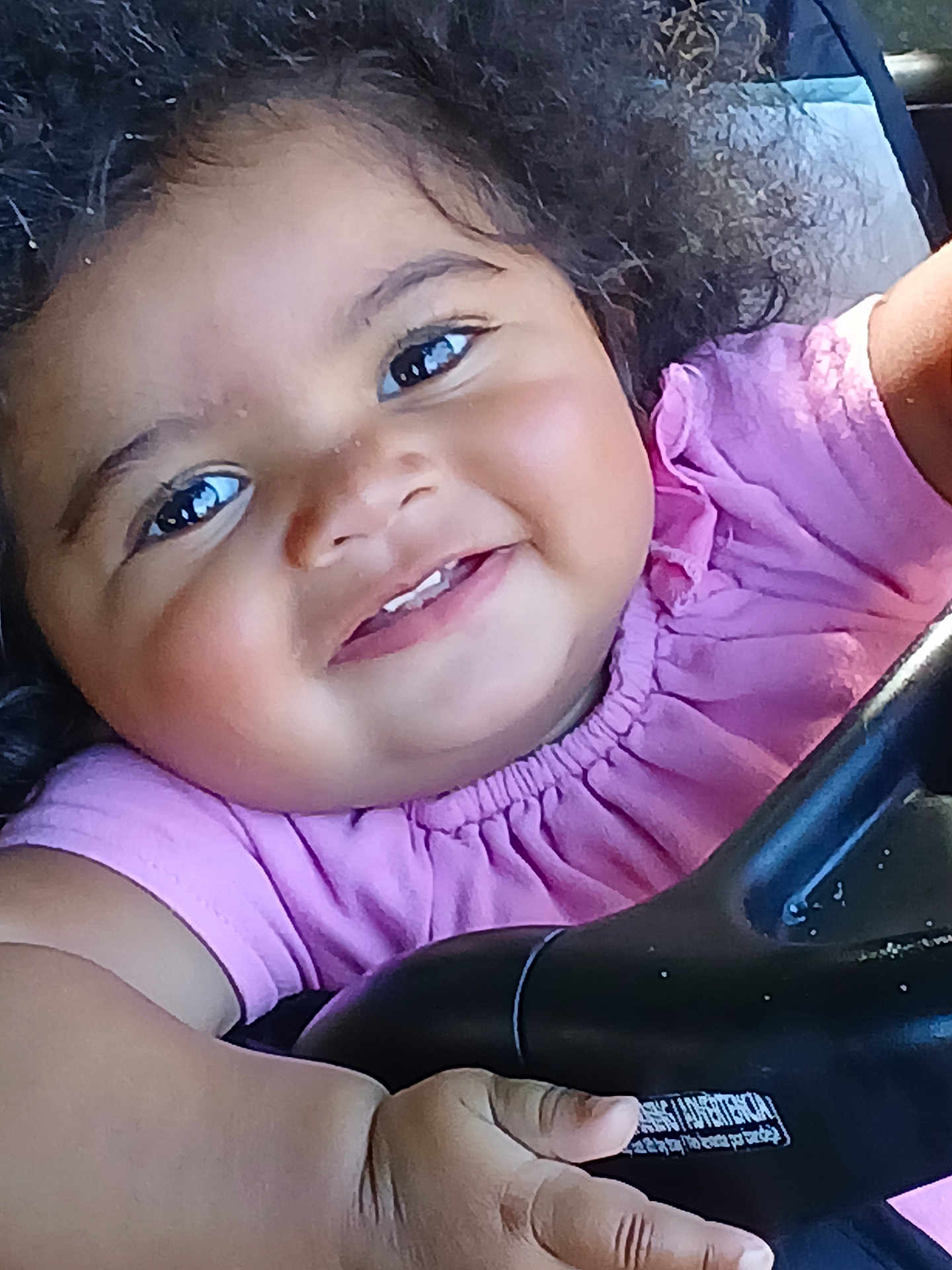 Akeilah is registered to the contest to win money with this photo: toddler, child, smiling, curly_hair, pink_shirt, close_up, hand, face, happy, baby, skin, person, eyes, cheeks, clothing, infant, cute, portrait, expression, holding